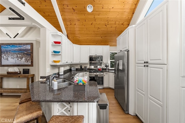 kitchen with appliances with stainless steel finishes, a breakfast bar, sink, and white cabinets