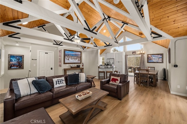 living room with beam ceiling, ceiling fan with notable chandelier, light hardwood / wood-style floors, and wooden ceiling