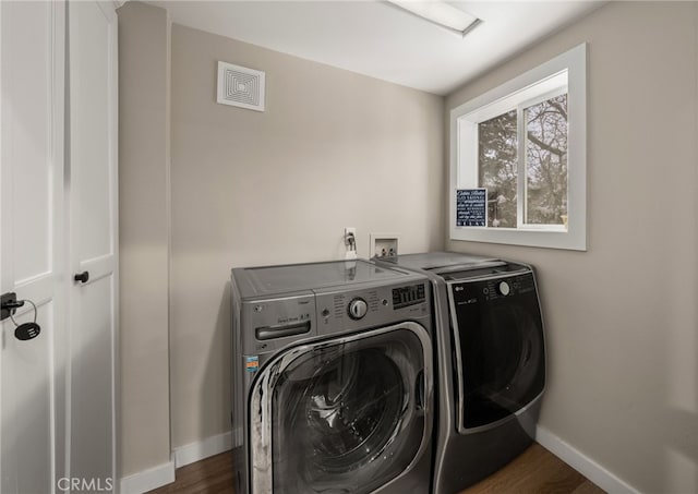 clothes washing area featuring dark hardwood / wood-style flooring and washing machine and dryer