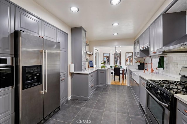 kitchen with sink, gray cabinetry, hanging light fixtures, a notable chandelier, and stainless steel appliances