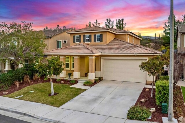 mediterranean / spanish-style house with a yard and a garage