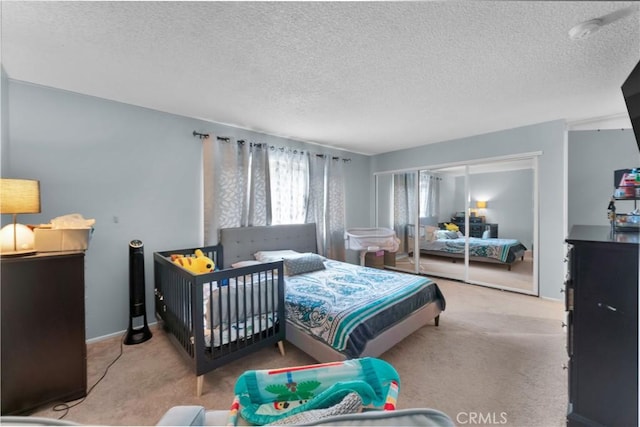 bedroom featuring light carpet and a textured ceiling