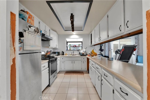 kitchen featuring stainless steel appliances, white cabinetry, sink, and light tile patterned flooring