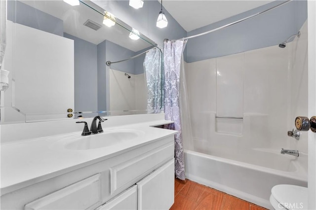 full bath with toilet, visible vents, wood finished floors, shower / bathtub combination with curtain, and vanity