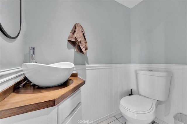 bathroom featuring wainscoting, toilet, vanity, and tile patterned flooring