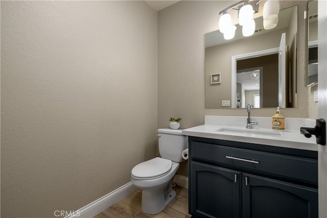 bathroom with hardwood / wood-style flooring, vanity, and toilet