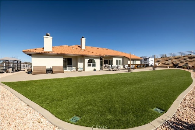 rear view of house featuring a patio and a yard