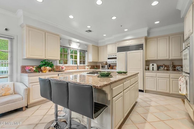 kitchen with crown molding, a kitchen island, plenty of natural light, and white appliances