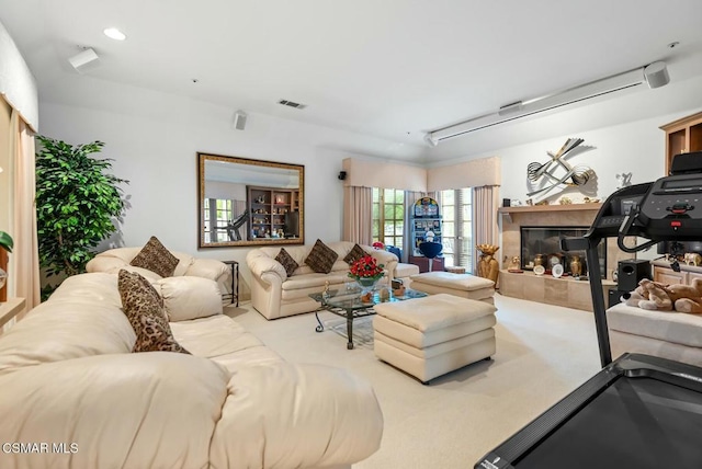 carpeted living room with a tiled fireplace