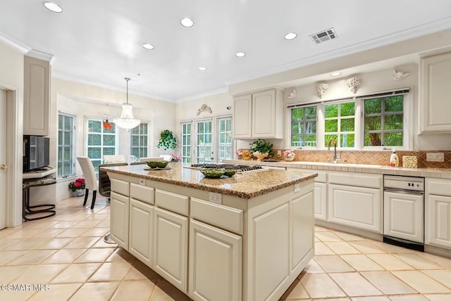 kitchen featuring crown molding, hanging light fixtures, backsplash, stainless steel gas cooktop, and a kitchen island