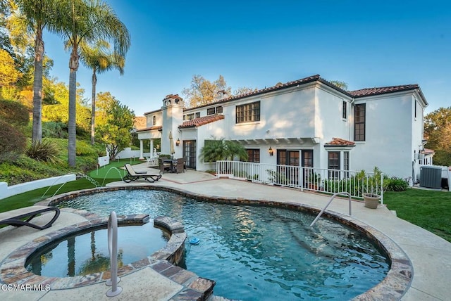 view of swimming pool with an in ground hot tub, a yard, a patio area, and central air condition unit