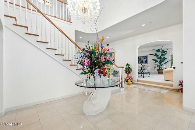 foyer entrance featuring light tile patterned floors and a high ceiling