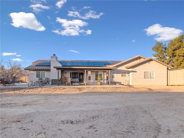 view of front of house featuring a patio area and solar panels