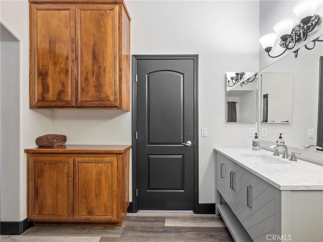 bathroom with vanity, wood-type flooring, and a notable chandelier