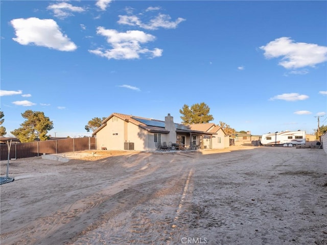 rear view of property featuring solar panels