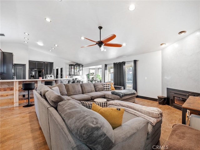 living room with lofted ceiling, light wood-type flooring, and ceiling fan