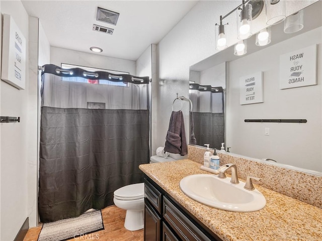 bathroom featuring vanity, curtained shower, and toilet