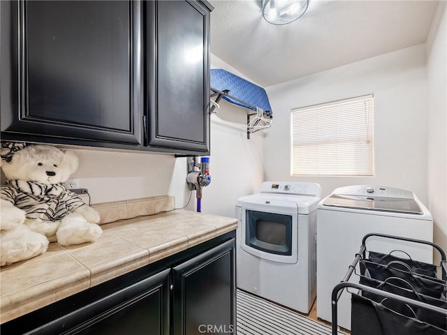 laundry area featuring washing machine and dryer and cabinets