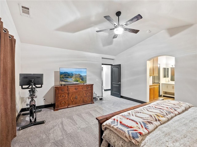 bedroom featuring ceiling fan, light colored carpet, lofted ceiling, and connected bathroom