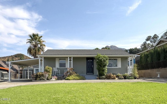 view of front of house with a carport and a front lawn