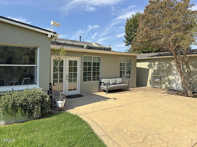 rear view of property with french doors and a patio area