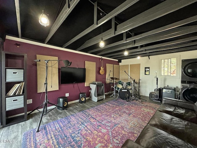 exercise room featuring stacked washer / drying machine and wood-type flooring