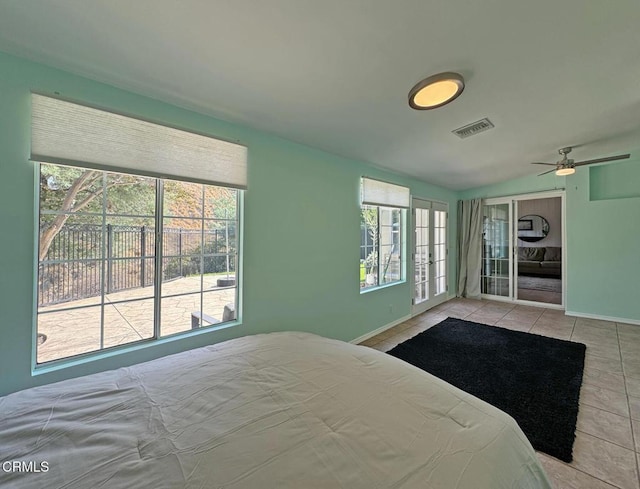 tiled bedroom featuring multiple windows and ceiling fan