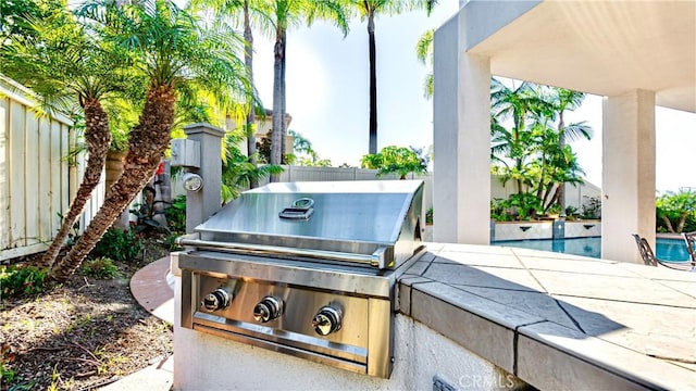 view of patio with area for grilling and a grill