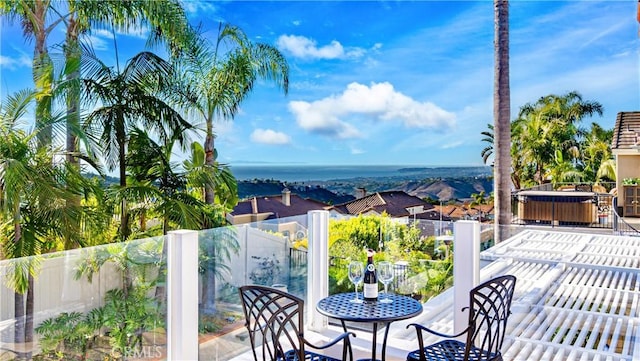 balcony featuring a hot tub and a water view