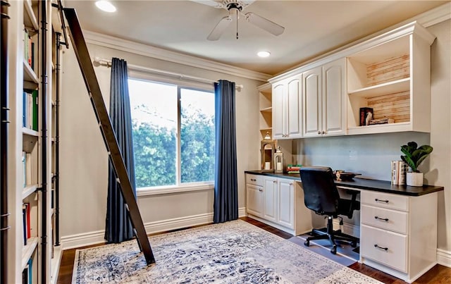 home office with ceiling fan, crown molding, built in desk, and dark hardwood / wood-style flooring