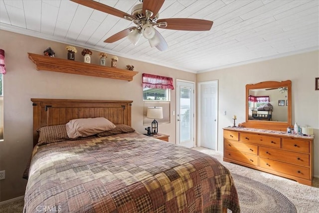 carpeted bedroom featuring wood ceiling, crown molding, and ceiling fan