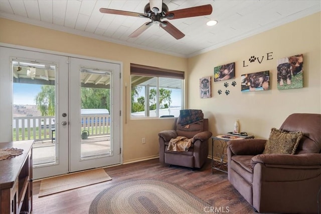 living area featuring dark hardwood / wood-style flooring, crown molding, french doors, and ceiling fan