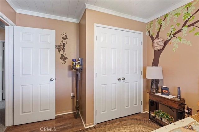 bedroom with crown molding, dark wood-type flooring, and a closet