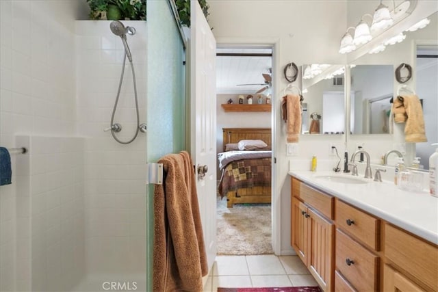 bathroom with tile patterned flooring, vanity, and tiled shower