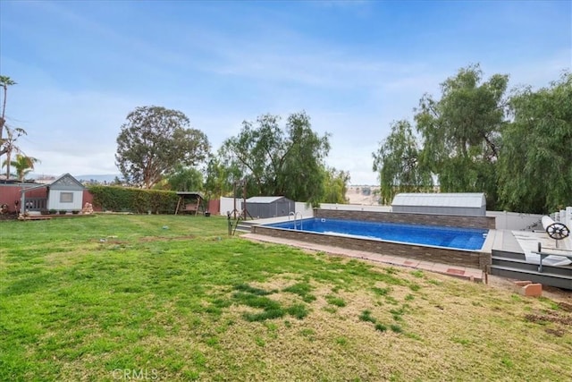 view of pool featuring a yard, a deck, and a shed