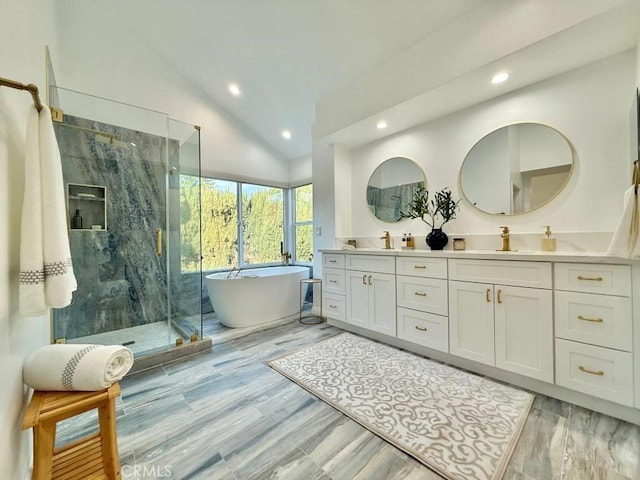 bathroom with lofted ceiling, vanity, wood-type flooring, and separate shower and tub