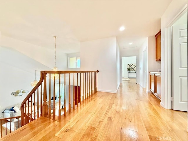 hallway featuring a notable chandelier and light hardwood / wood-style flooring