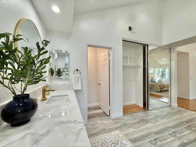 bathroom featuring a high ceiling and vanity