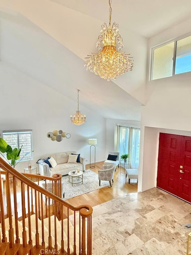 living room featuring wood-type flooring, a chandelier, and a high ceiling