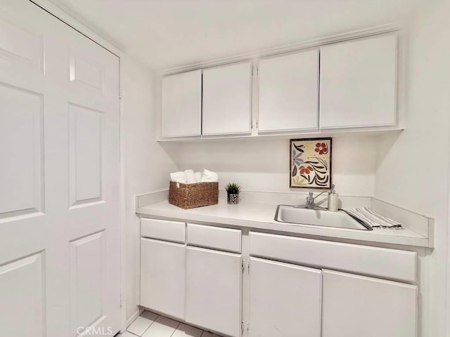 kitchen featuring light tile patterned flooring, sink, and white cabinets