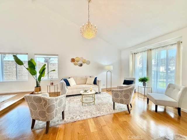 living room featuring high vaulted ceiling, a notable chandelier, and light wood-type flooring