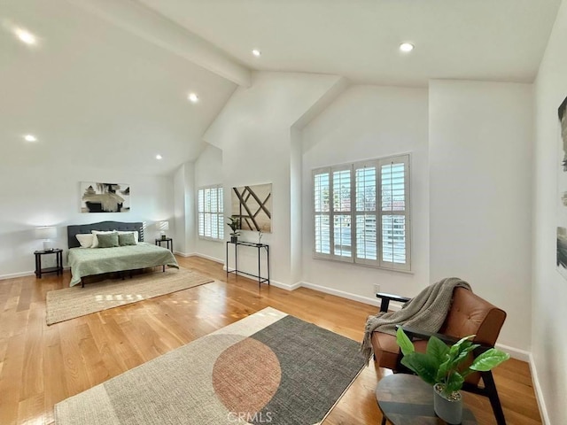 sitting room featuring beam ceiling, light hardwood / wood-style flooring, and high vaulted ceiling