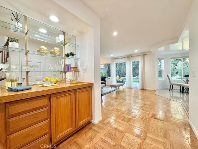 bar featuring sink, butcher block countertops, and light parquet floors