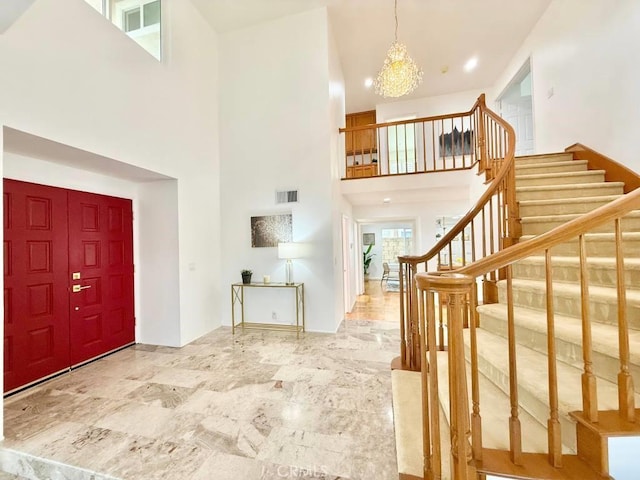 entrance foyer featuring a towering ceiling and a notable chandelier