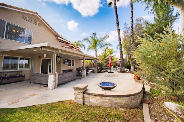 view of patio with an outdoor living space with a fire pit