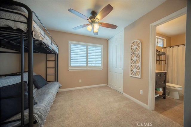 carpeted bedroom with connected bathroom and ceiling fan