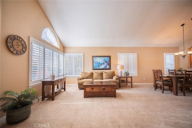 carpeted living room featuring high vaulted ceiling and a chandelier