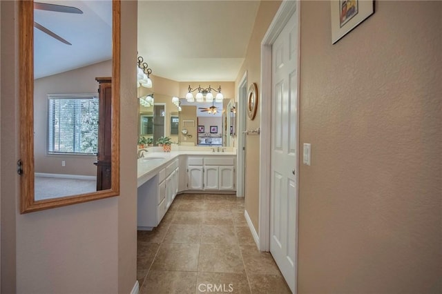 bathroom with tile patterned flooring, vanity, lofted ceiling, and ceiling fan