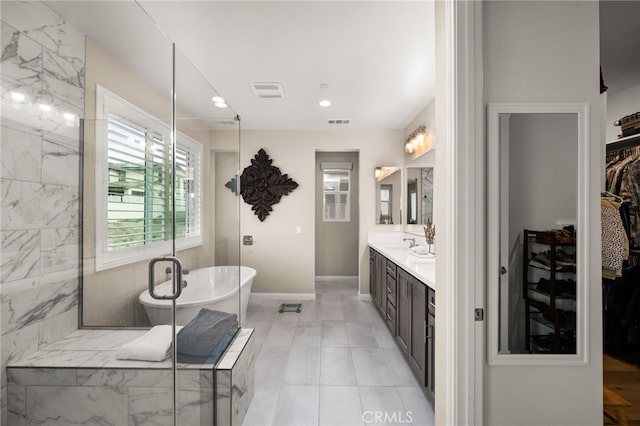 full bath featuring a shower with door, a soaking tub, visible vents, vanity, and baseboards