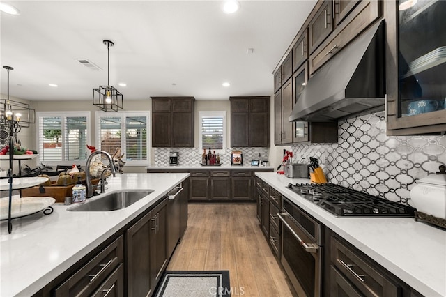 kitchen with visible vents, appliances with stainless steel finishes, light countertops, under cabinet range hood, and a sink